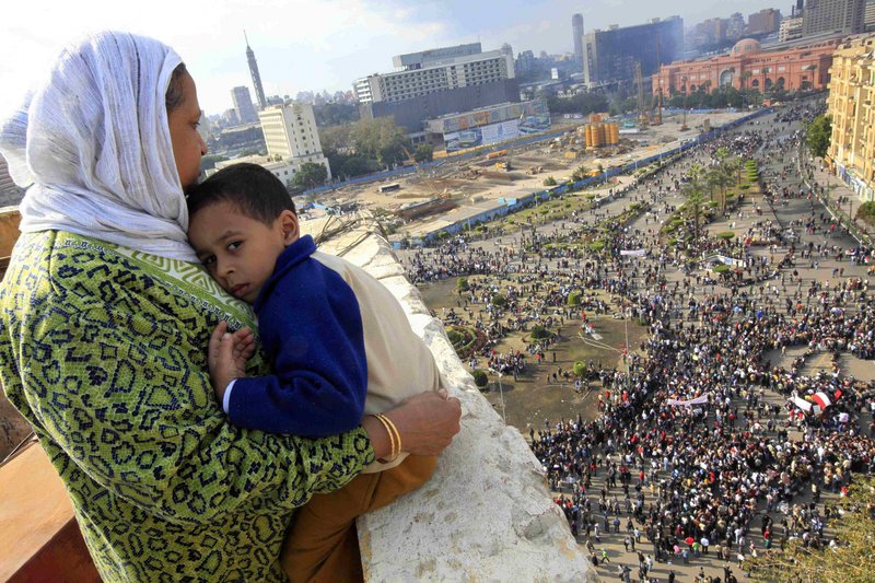 An Egyptian mother hugs her child as she watches some thousands of Egyptian protesters gather at Tahrir Square in Cairo on Sunday.