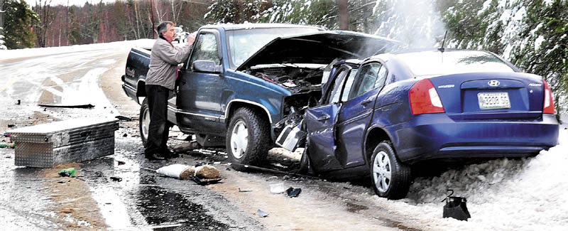 Frank Keithan of Troy speaks with two injured occupants of a pickup truck that collided head- on with a Hyundai where a woman driver died of injuries on slush-covered Route 139 in Unity Township on Wednesday.