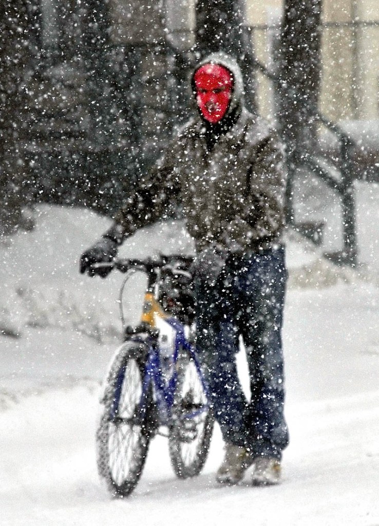 SNOW PROBLEM: Leonard Greeley walks his bike along Ticonic Street in Waterville during a windy snowstorm on Wednesday. Greeley said he did not mind using a bike in the snow saying, "You have to watch for the ice and that fishtail thing."