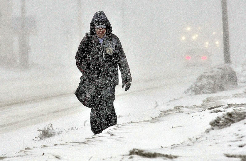 Staff photo by David Leaming WEATHER OR NOT: Mail carrier Jim Waters makes his way along Kennedy Memorial Drive in Waterville during the snowstorm on Wednesday. Asked about the working outdoors during inclement weather Waters shrugged his shoulders and said," It's something I got to do."