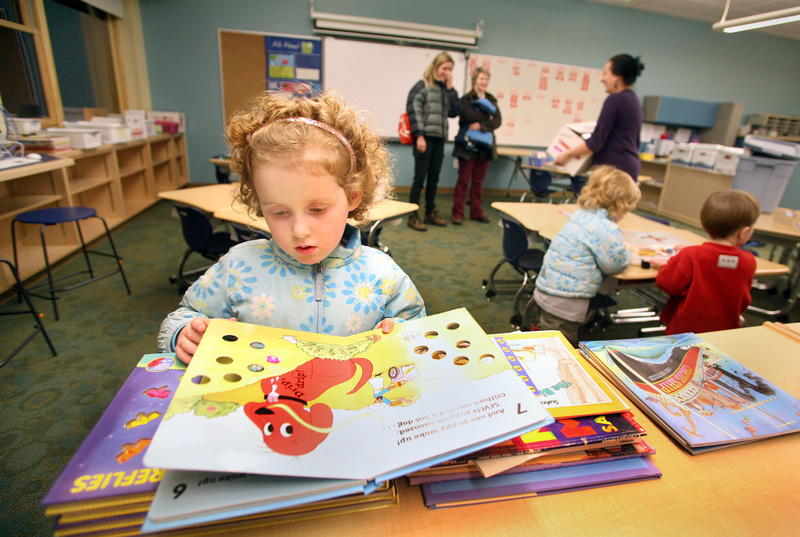Emma King, 5, of Portland checks out the book selection in the kindergarten room during an open house Wednesday evening at the city’s new Ocean Avenue Elementary School, which officially opens for students Feb. 28. Emma will start kindergarten at the school next year.