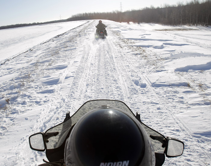 In this Feb. 10, 2011, photo, U.S. Border Patrol agents Glenn Pickering, front, and Janice Jones ride snowmobiles along the St. Lawrence River in Massena, N.Y.