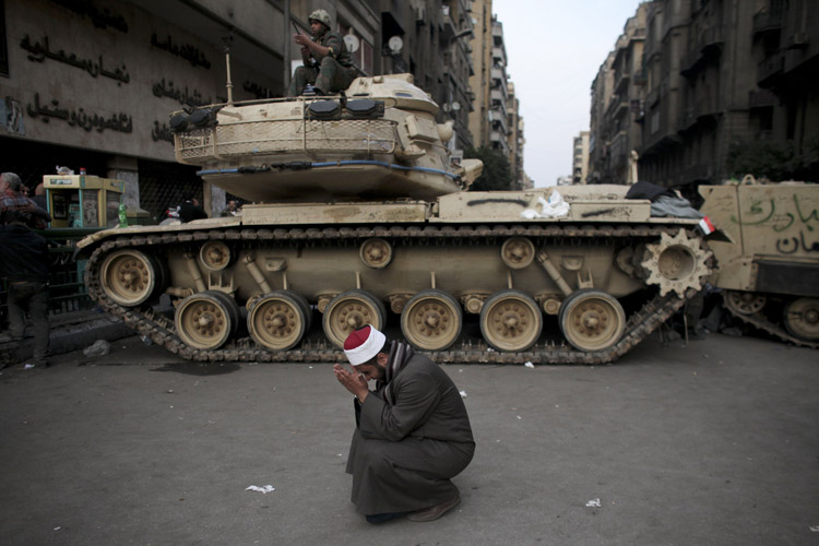 An Egyptian cries in front of on army tank in Tahrir, or Liberation square, in Cairo today, where several thousand supporters of President Hosni Mubarak, including some riding horses and camels and wielding whips, clashed with anti-government protesters.