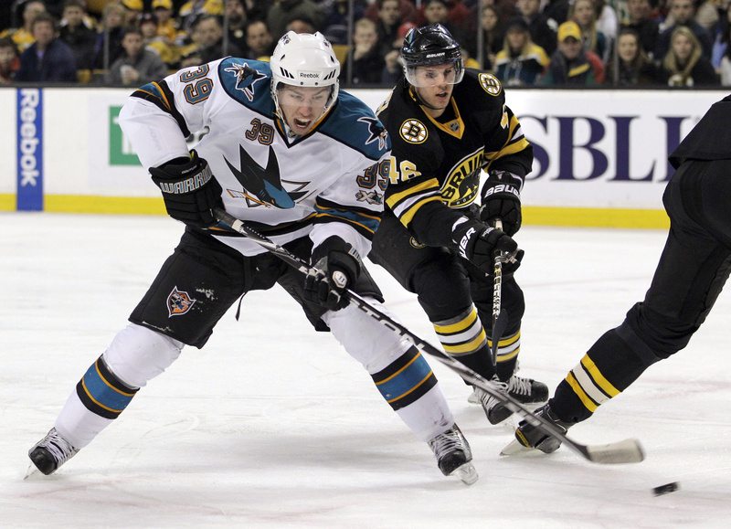 Logan Couture of the Sharks shoots and scores as Boston's David Krejci defends during the first period today in Boston. The Sharks added an empty-net goal in the final seconds for a 2-0 win.