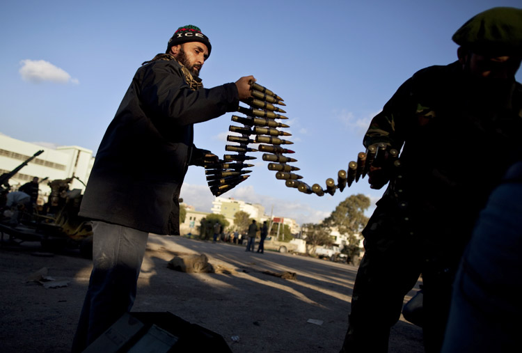 A Libyan rebel, left, and a defector from the Libyan Army who are now part of the forces against Moammar Gadhafi organize ammunition at a military base in Benghazi, in eastern Libya, today.