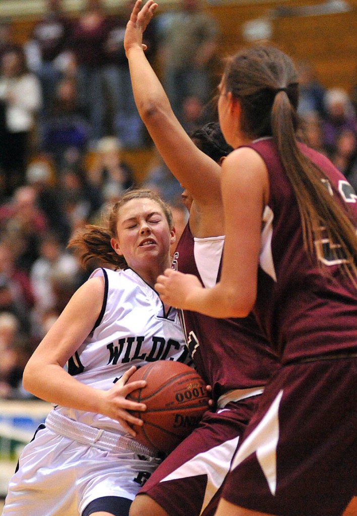 Staff photo by Michael G. Seamans Presque Isle High School's Chandler Guerrette, left, drives to the basket as Nokomis' Julie Smith, center, and Danielle Watson defend in the second quarter of the Eastern Maine Class B semifinals at the Bangor Auditorium Wednesday, Feb. 23. Nokomis defeated Presque Isle 49-43.