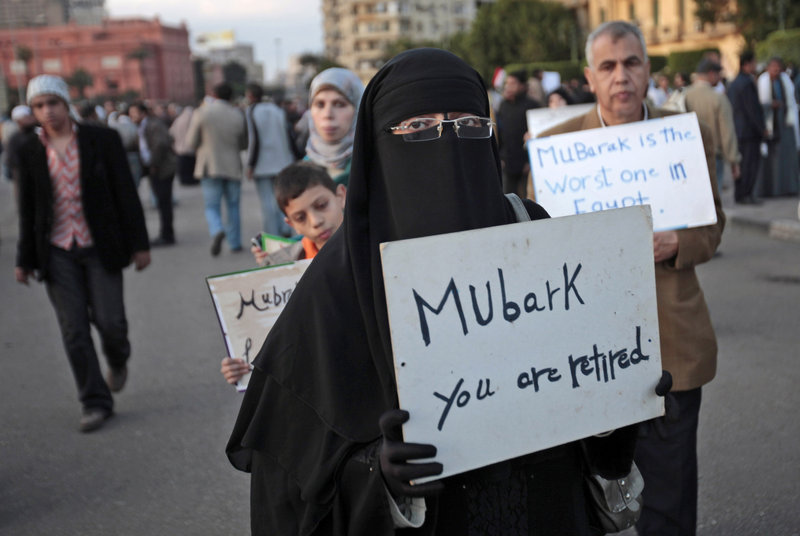 Anti-government protesters carry handwritten signs Monday in Cairo’s Tahrir Square. A coalition of opposition groups called for a million people to take to the city’s streets today to demand the removal of President Hosni Mubarak.