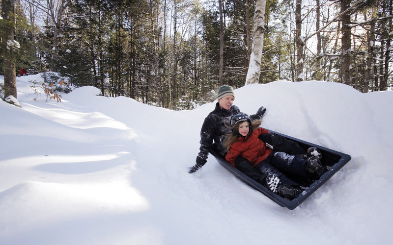 Andy Russ and his daughter Maddy, 7, ride down the family’s luge run behind their house in Damariscotta on a recent Saturday. The Russes get in a few runs most mornings before school and work.