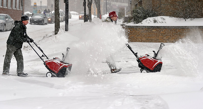 Jay Downs of Commercial Property Services, left, and Tom Moulton of the Dunham Group clear the sidewalks at Two Monument Square.