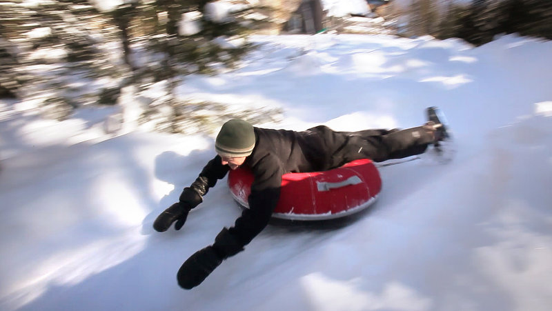 Andy Russ takes a luge run on a tube. The Russes started building their course four years ago, and this winter’s abundant snow has given them more frequent use of it.