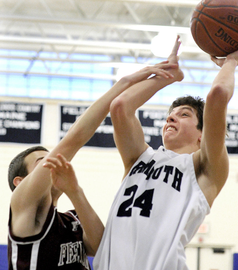 Aiden Sullivan of Yarmouth shoots while keeping the ball from Aaron Berkemeyer of Freeport.