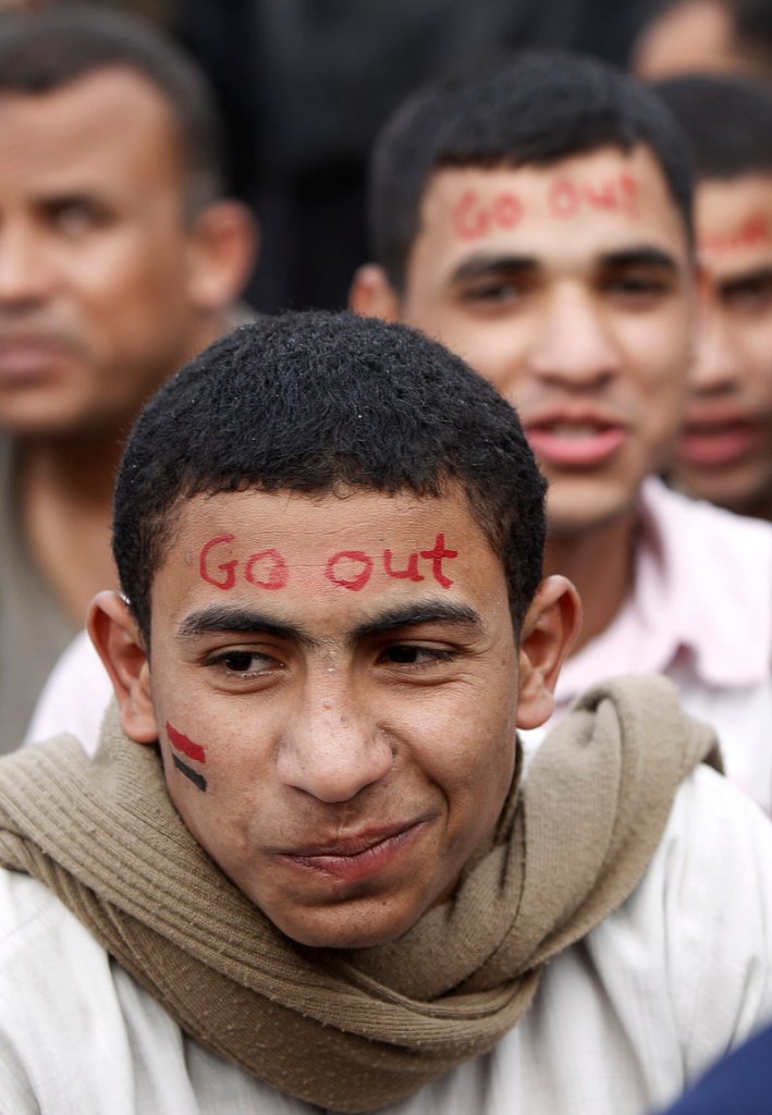 Anti-government protesters have slogans and national flags painted on their faces in Tahrir Square in Cairo.