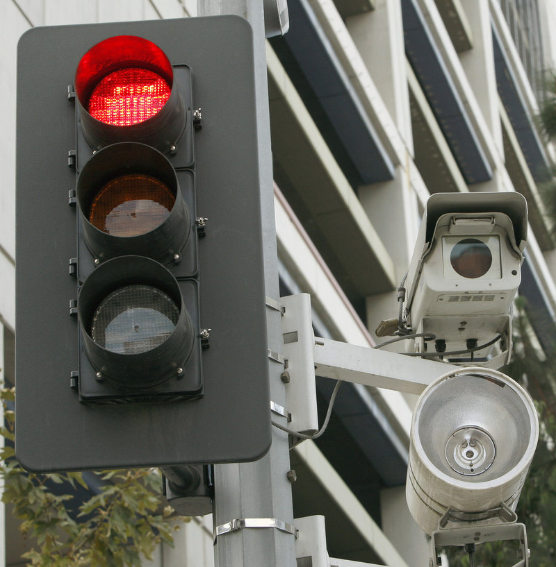 Red light cameras, like this Los Angeles one, have saved 159 lives over five years in 14 cities, a report concludes.