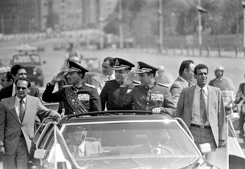 In this photo from 1981, Egyptian President Anwar Sadat, left, salutes from a Cairo motorcade. At right is Vice President Hosni Mubarak, who would become president after Sadat’s assassination by Muslim militants in 1981.