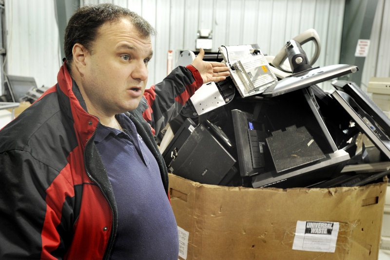 Rick Dumas, CEO of eWaste Recycling Solutions, LLC, in Auburn, points out all of the old TV sets, computer monitors and other electronic devices that await dismantling for recycling.