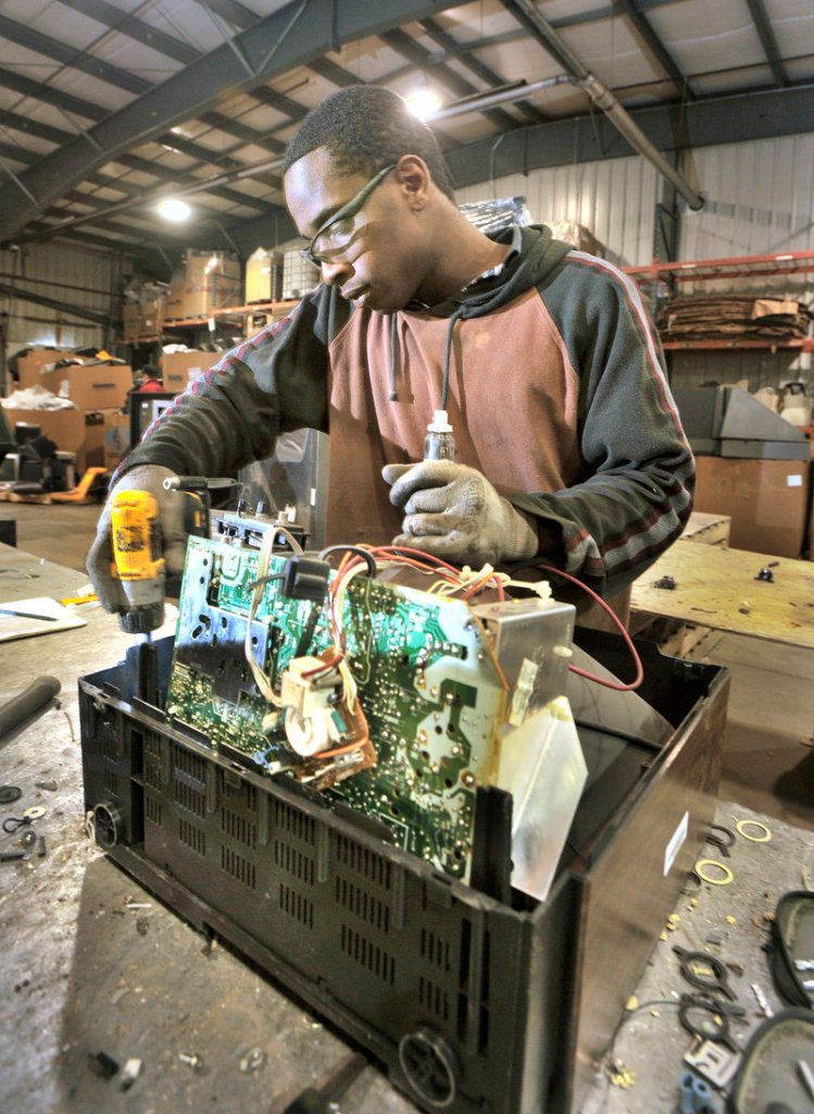 Christopher Pagon of Auburn dismantles an old television at eWaste Recycling Solutions. Maine’s electronic waste law has saved municipal taxpayers about $7 million in disposal costs.