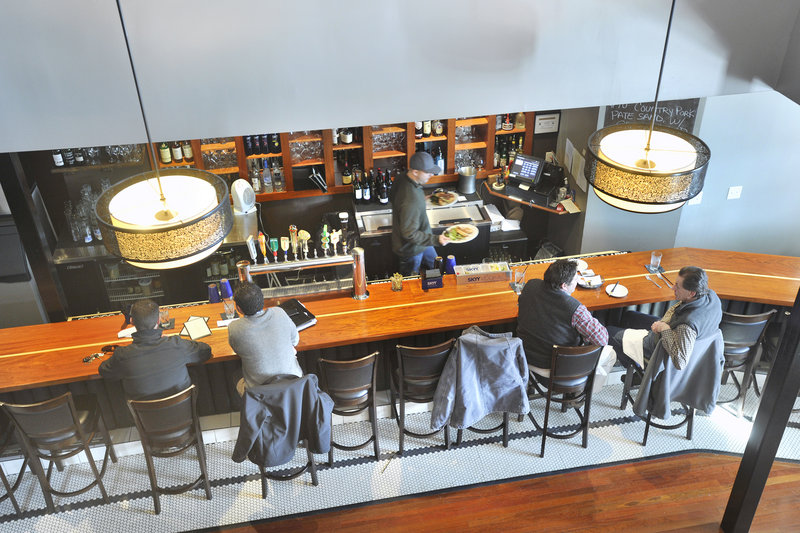 At District, a railed opening on the second floor overlooks the bar and is a comfortable place to perch, people watch and drink a glass from a good wine list.