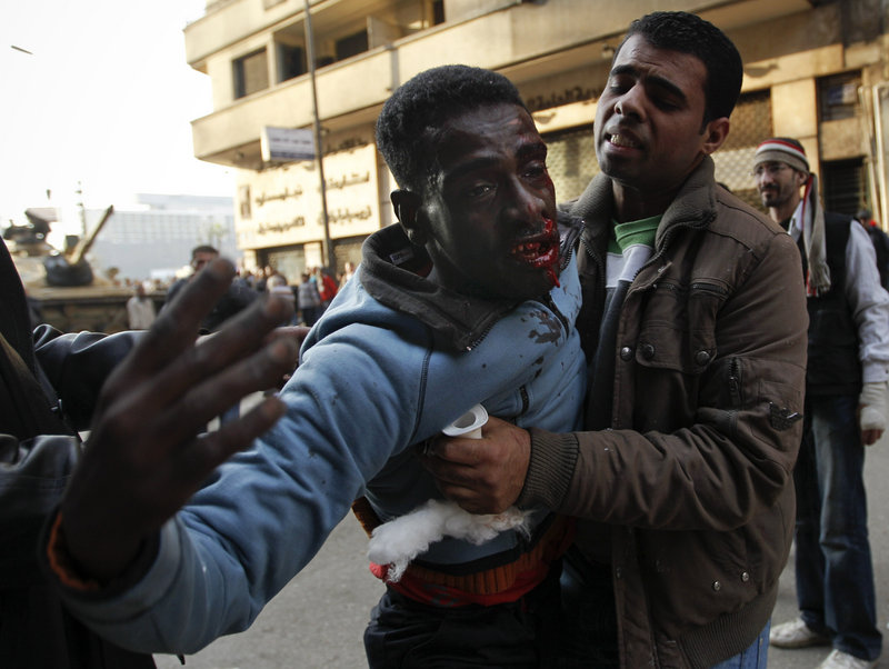 A medic attempts to treat an injured anti-government protester during clashes Wednesday with thousands of Mubarak supporters in Cairo s Tahrir Square.