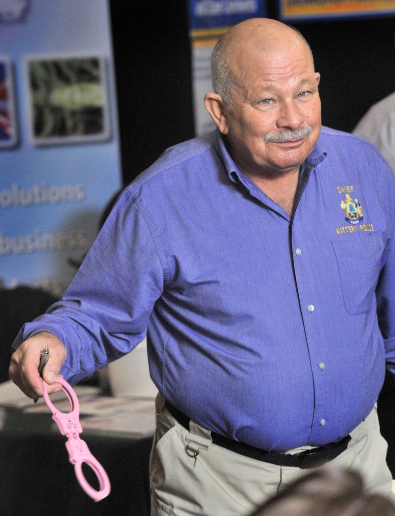 Ed Strong, Kittery police chief, holds pink handcuffs from a vendor at the Maine Chiefs of Police Association annual convention at the Wyndam Hotel in South Portland.