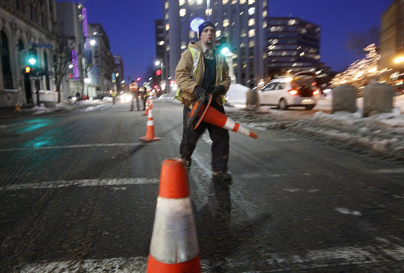 A Unitil worker lays down cones Thursday evening after a gas leak forced the closure of one lane of Congress Street near the intersection of Preble Street in Portland.