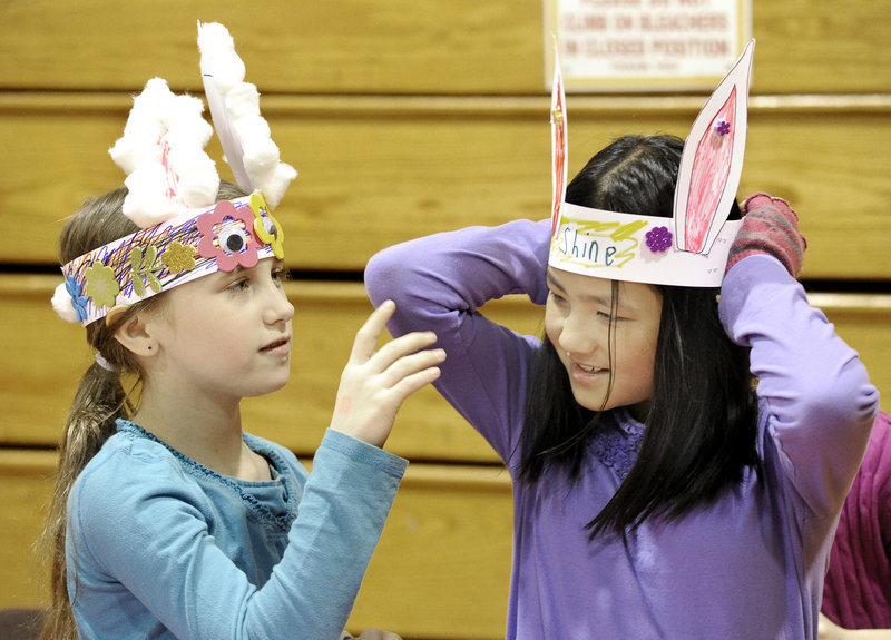 Nine-year-olds Abigale O’Brion of Hollis and Grace Soares of Westbrook try on rabbit headdresses they’d made during a Chinese New Year event at McAuley High School.
