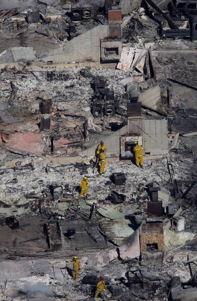 Fire crews examine the remains of homes damaged by a massive fire last September in a mostly residential neighborhood in San Bruno, Calif. An Associated Press investigation found that the utility, Pacific Gas & Electric Co., agreed years ago that remotely operated valves did a better job of protecting public safety than manual ones. But it opted against using them widely across its network.