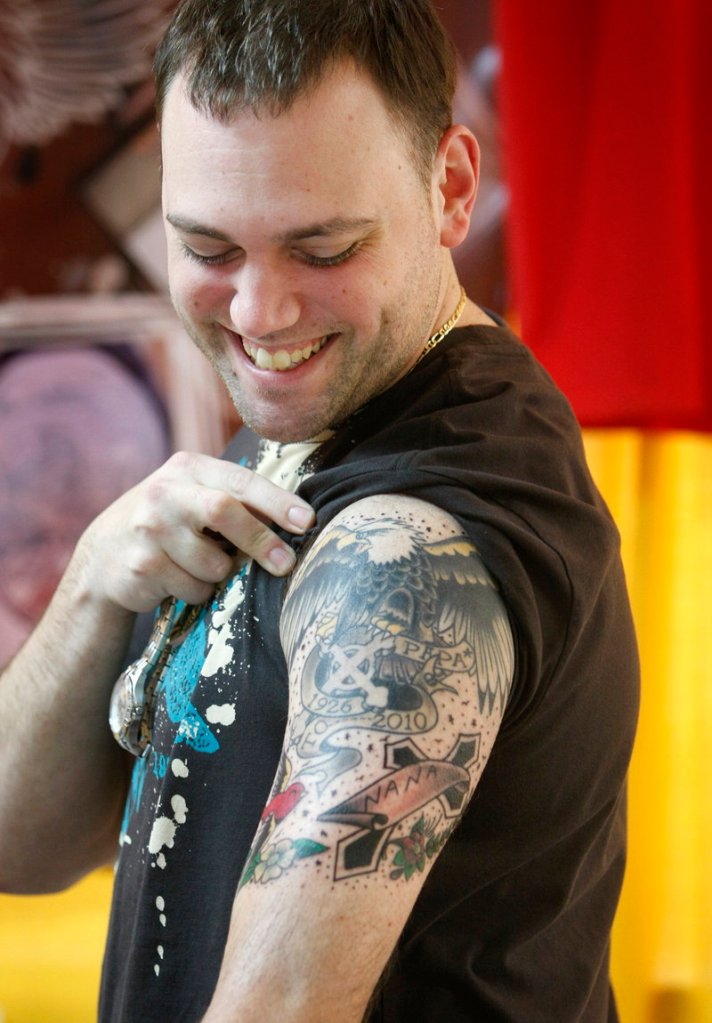 Dan Doyle of West Warwick, R.I., admires his new tattoo by Dennis Correia, also of Rhode Island, at the Hatter Remains Reunion Tattoo Show, held Sunday at the Best Western Merry Manor in South Portland. The tattoo, Doyle said, is a tribute to his grandfather, who raised him and had an eagle tattoo of his own from World War II.