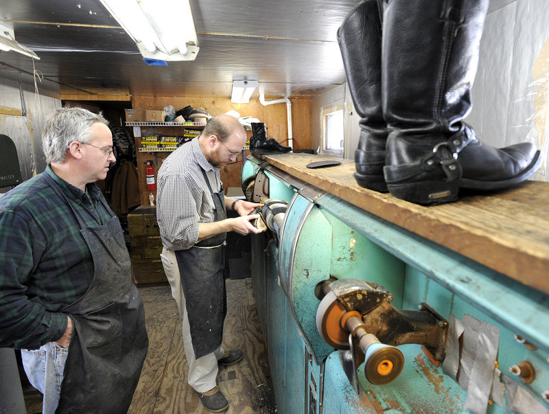 Ray Routhier, right, works on one of the machines with Paul Rowland at Paul's Shoe Repair in Westbrook.