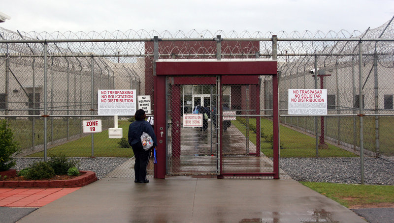 An employee waits at the front gate of the Stewart Detention Facility, a Corrections Corp. of America immigration facility in Lumpkin, Ga. CCA has dusted off its three-year-old plan for a prison in Milo and is open to new discussions, said Town Manager Jeff Gahagan.