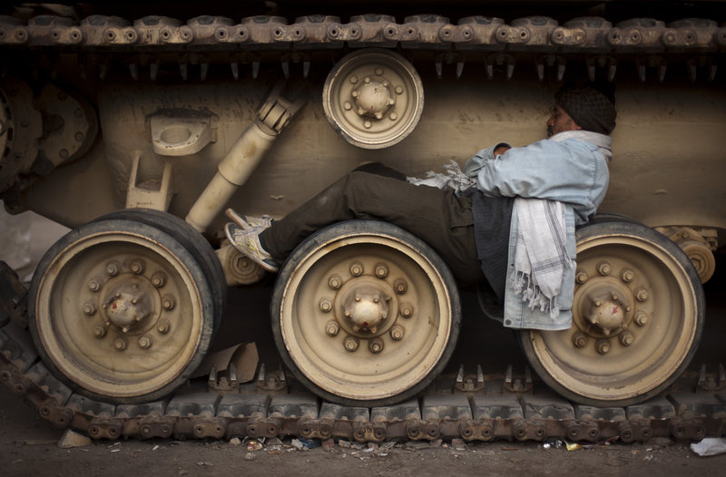 An Egyptian anti-Mubarak protester sleeps on the wheels of a tank at Tahrir Square in Cairo, Egypt, on Sunday.