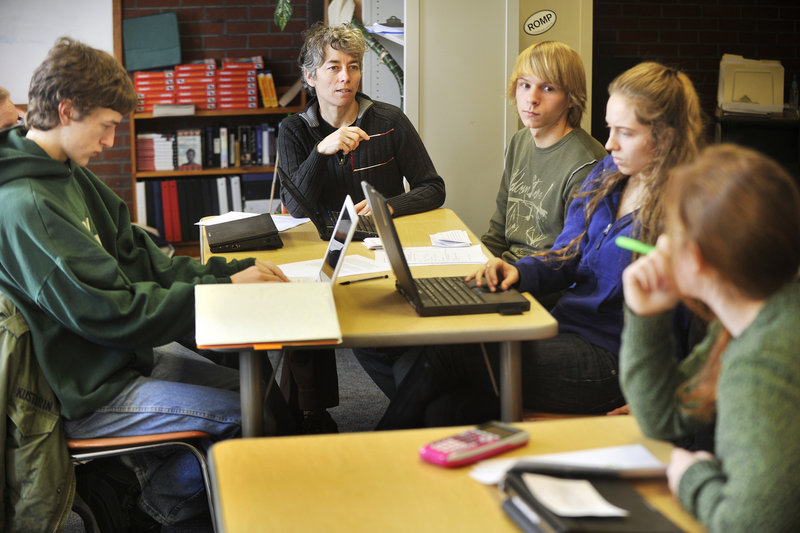 Teacher Susan McCray works with humanities students Monday at Casco Bay High School in Portland. Started in 2005, the school emphasizes real-world learning experiences.