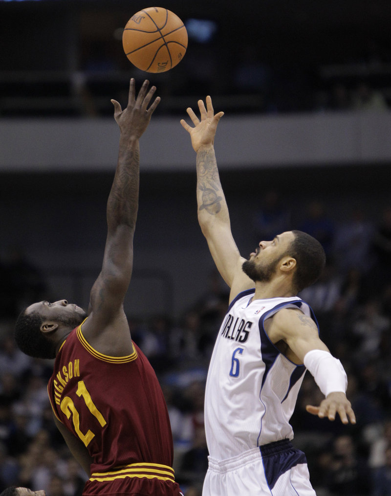J.J. Hickson of the Cavaliers and Dallas’ Tyson Chandler work for the ball Monday. The Cavs extended the worst NBA losing streak in history to 25 games.