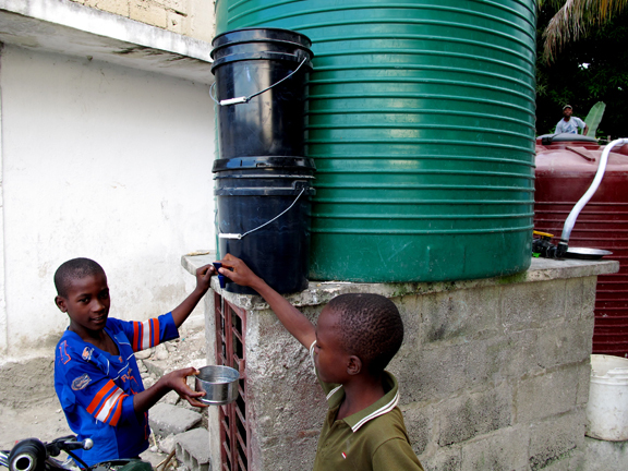Two children check the water coming through the new filtration system.