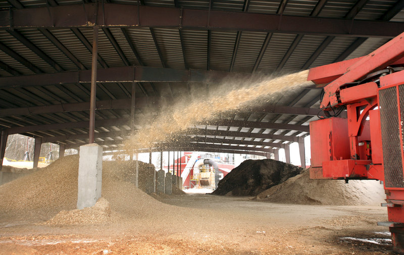 A wood chipper shoots chips into a pile for drying at the plant that produces Maine’s Choice premium wood pellets.