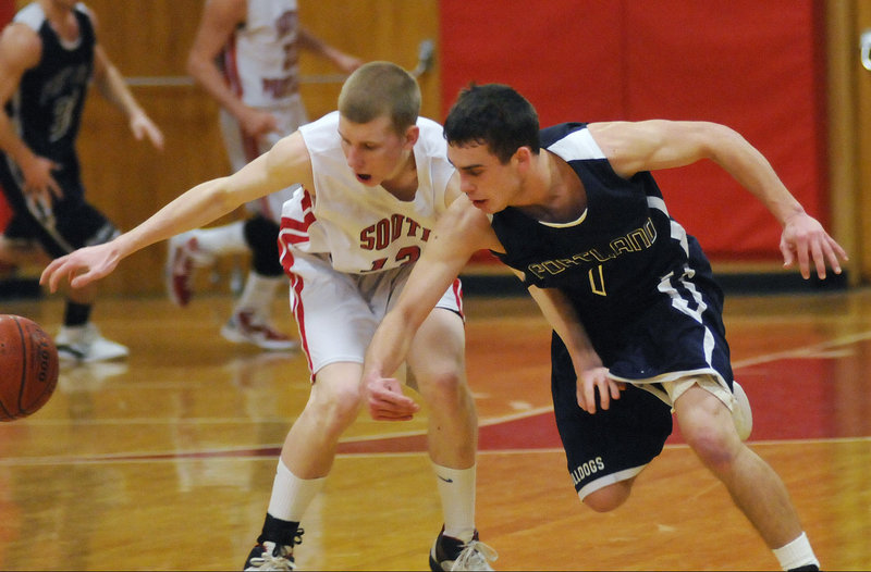 Tanner Hyland of South Portland, left, and Nick Volger of Portland fight for a loose ball Tuesday night. Peter Donato led Portland with 18 points.