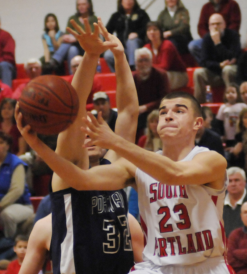 South Portland s Vukasin Vignjevic drives to the basket as Portland s Mike Herrick moves in Tuesday night at Beal Gym. Portland completed a two-game sweep of the Red Riots.