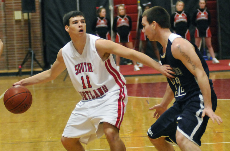 South Portland s Steve Hodge, left, holds off Portland's Mike Herrick while looking for an open teammate Tuesday night at South Portland. The Bulldogs won, 59-54.