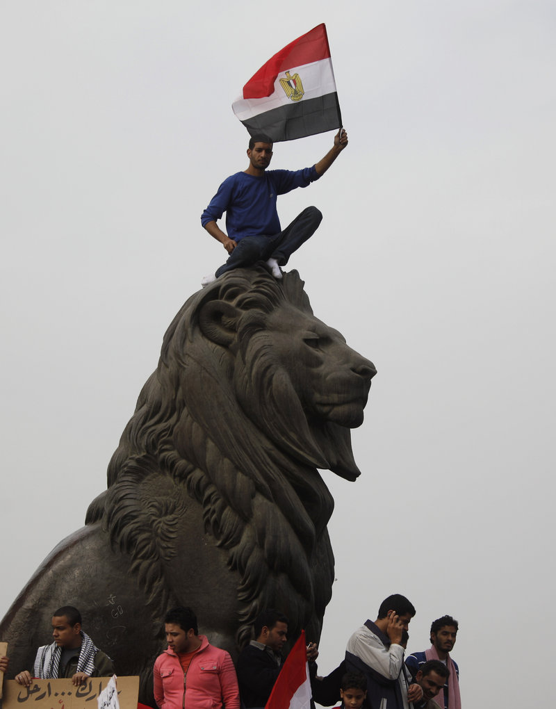 An Egyptian waves his national flag just outside Tahrir Square in Cairo. Protesters said Tuesday they fear that if the crowds disperse but Hosni Mubarak remains in power, they might be attacked, jailed or even killed.