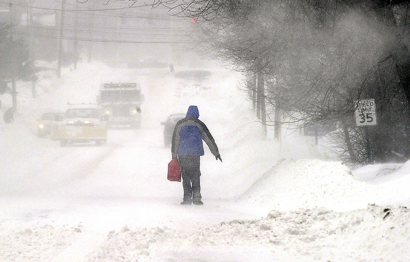 A person carries a gas can down a South Portland street during a recent snowstorm. Readers say weather reports make too much of such routine hardships.