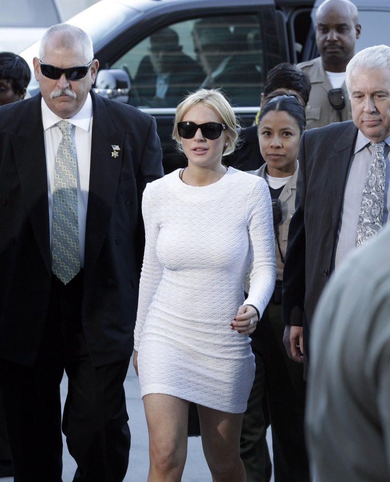 Actress Lindsay Lohan, center, arrives at the LAX Airport Courthouse in Los Angeles on Wednesday, to be arraigned on a felony grand theft charge.
