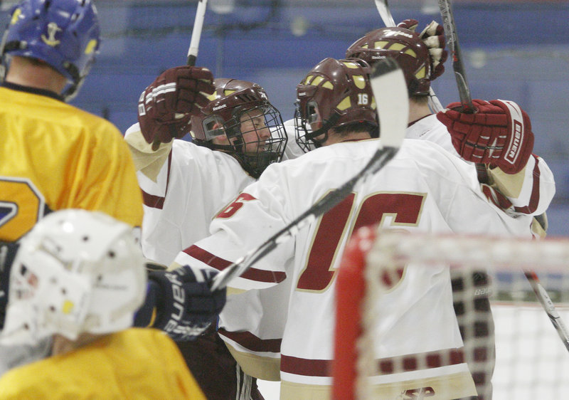 Greg Lodge, left, of Thornton Academy celebrates with teammates Wednesday night after Jonathan Herlihy scored in the second period to make it a 2-2 game – part of a 7-3 victory against Falmouth at the Biddeford Ice Arena.