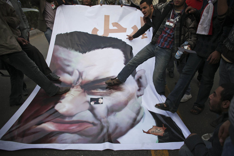 Anti-government protesters stomp on a poster of Egyptian President Hosni Mubarak on Wednesday outside the parliament building in Cairo. About 2,000 protesters waved huge flags outside parliament after moving four blocks from Tahrir Square, creating a second front in their bid to push Mubarak from power.