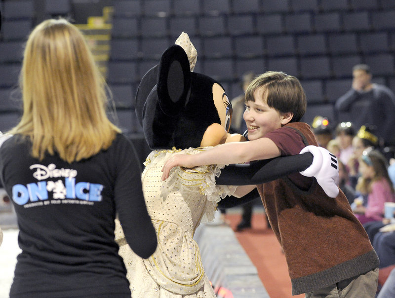 Peter Mahoney, 13, gets a hug from Minnie as performers from Disney On Ice conduct a skating clinic for Maine Special Olympics athletes at the Cumberland County Civic Center in Portland.