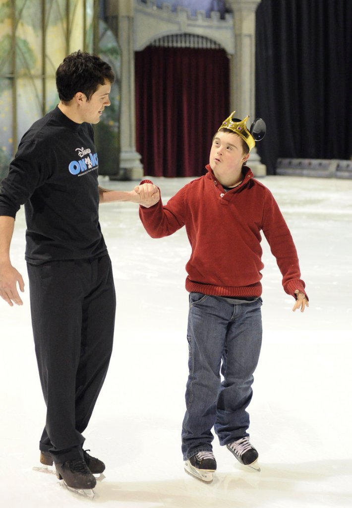 Disney on Ice’s Conrad Giering skates with Caleb Dunlap, 15, of Gorham during Thursday’s Special Olympics clinic.