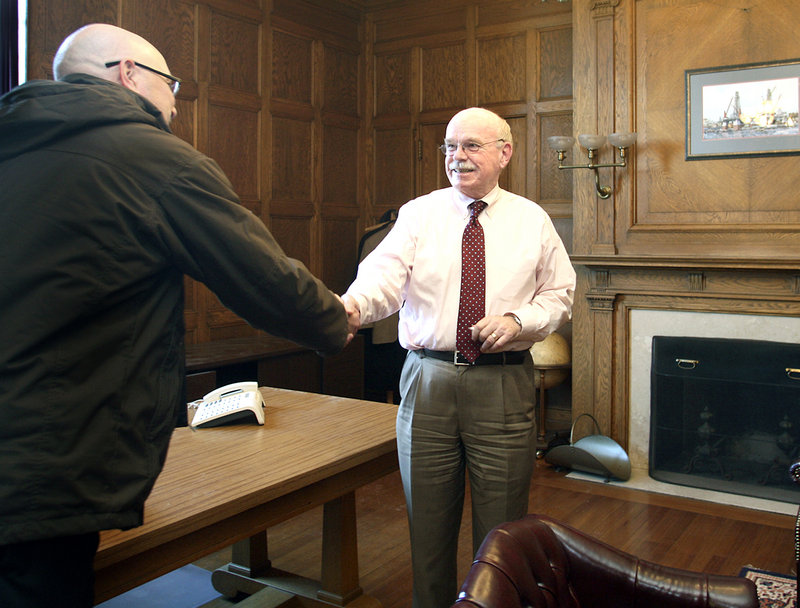 Eric Labelle, left, Portland’s assistant director for the department of public services, says goodbye to Joe Gray, retiring Portland city manager, in his office at City Hall on Thursday. According to Gray, Portland has benefited by building its economic ties to tourism and biotechnology.