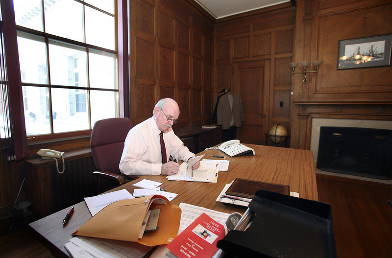 Joe Gray, retiring after 10 years as Portland’s city manager, takes care of some final paperwork in his City Hall office on Thursday.