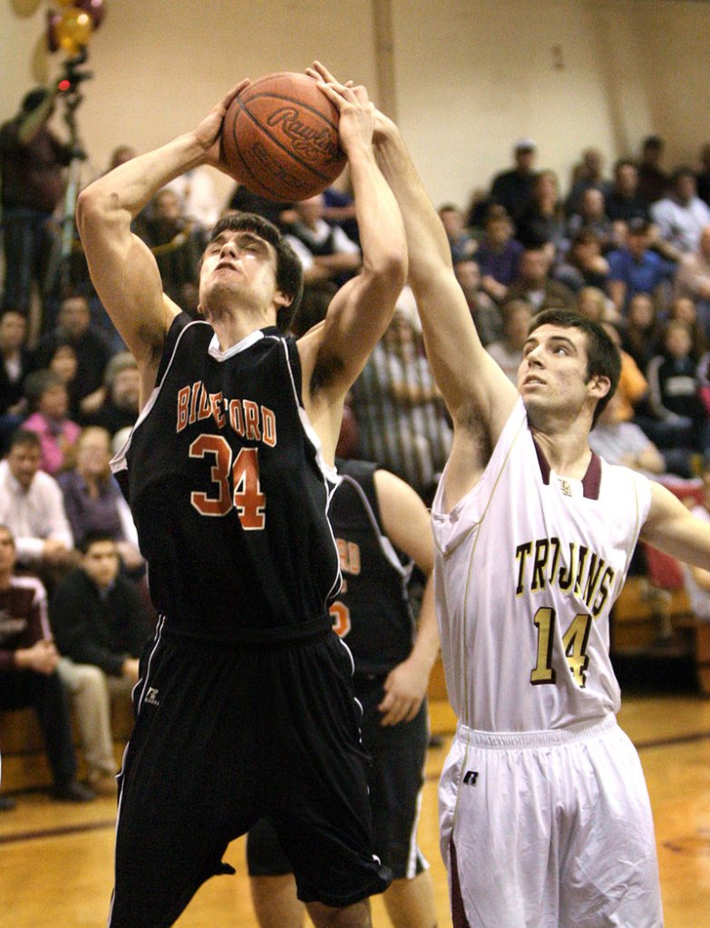 Chance Baldino of Biddeford, left, has his shot blocked by Josh Woodward of Thornton Academy during the first half Thursday night. Thornton won 72-70 in double overtime.