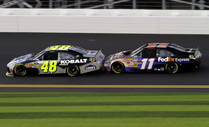 Jimmie Johnson, left, leads Denny Hamlin around the track at Daytona International Speedway during a practice session Friday. The two drivers race for Joe Gibbs Racing, which is celebrating its 20th year of racing and harbors hopes of winning another NASCAR title.
