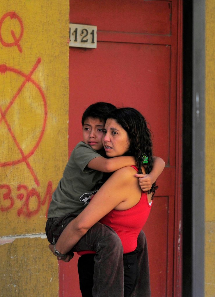 A frightened woman and child evacuate a building as a precaution after a magnitude-6.8 earthquake struck in Concepcion, Chile, on Friday.