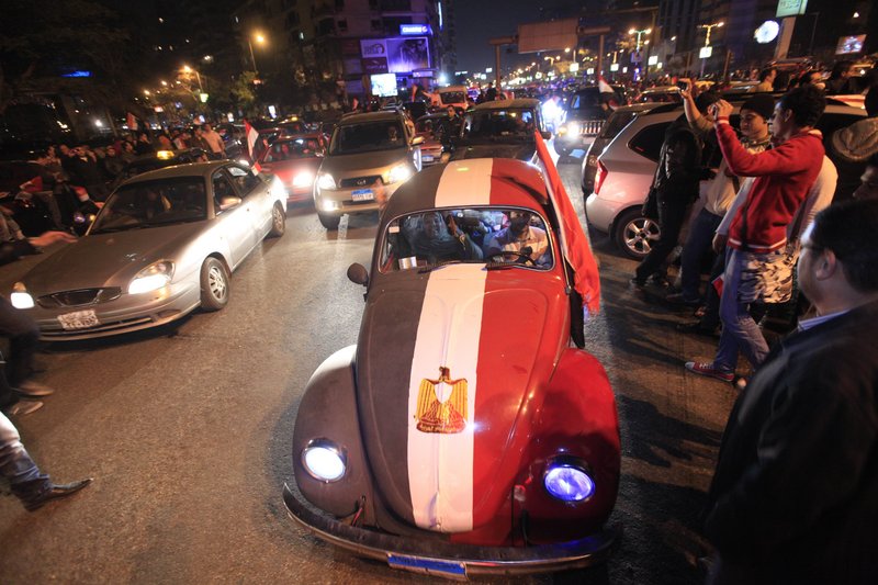 A Volkswagen Beetle, left, is painted in the colors of the Egyptian flag in the capital city during the raucous celebrations Friday.
